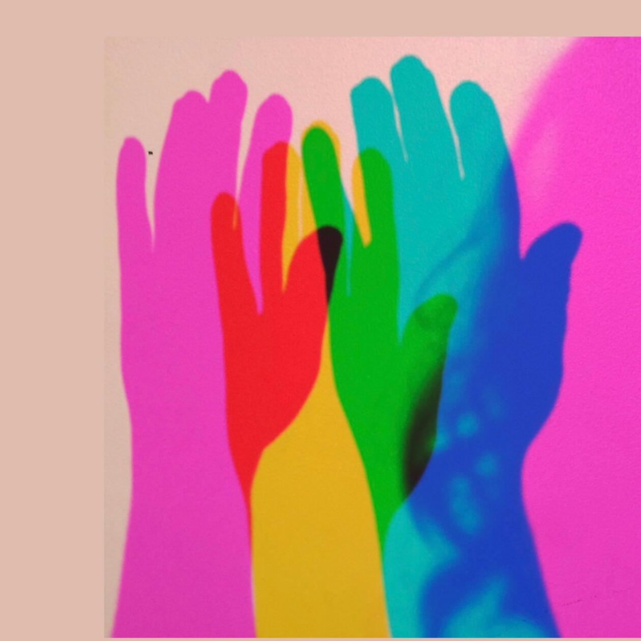 My hand casts three overlapping shadows of many colors (magenta, red, yellow, black, green, blue) because my hand is backlit with primary colors.