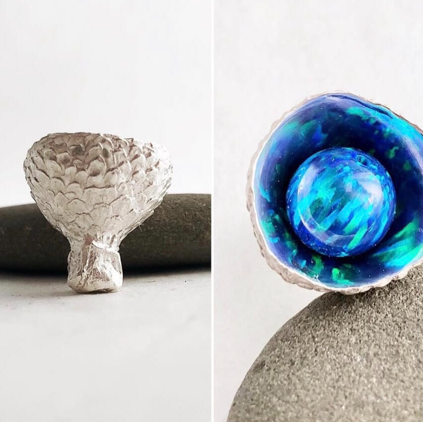 A silver acorn cup is polished to a high shine on the inside, so that the opal it contains shimmers like water. Jessica made this!